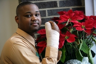 Curtis Faulkner, 30, cut his hand while using a utility knife to cut a candy cane stake. The Southfield dad is one of thousands of people who have visited the ER because of holiday-related injuries. "The knife just slipped. It started at the tip of my thumb ... through my knuckle and into the palm of my hand."   (WILLIAM ARCHIE/Detroit Free Press)